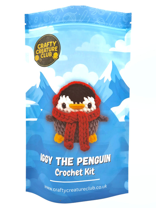 Crochet kit packaging for 'Iggy the Penguin' with a blue background and Crafty Creature Club branding.