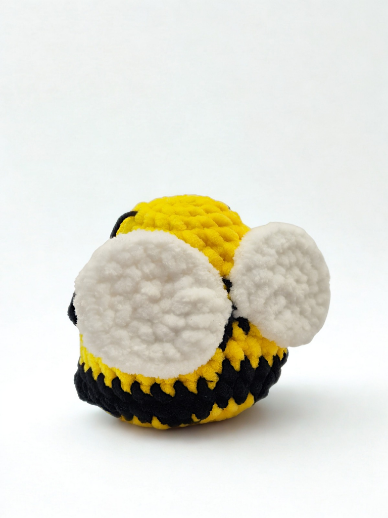 Close-up of Kobe the bumblebee amigurumi crocheted in plush chenille yarn