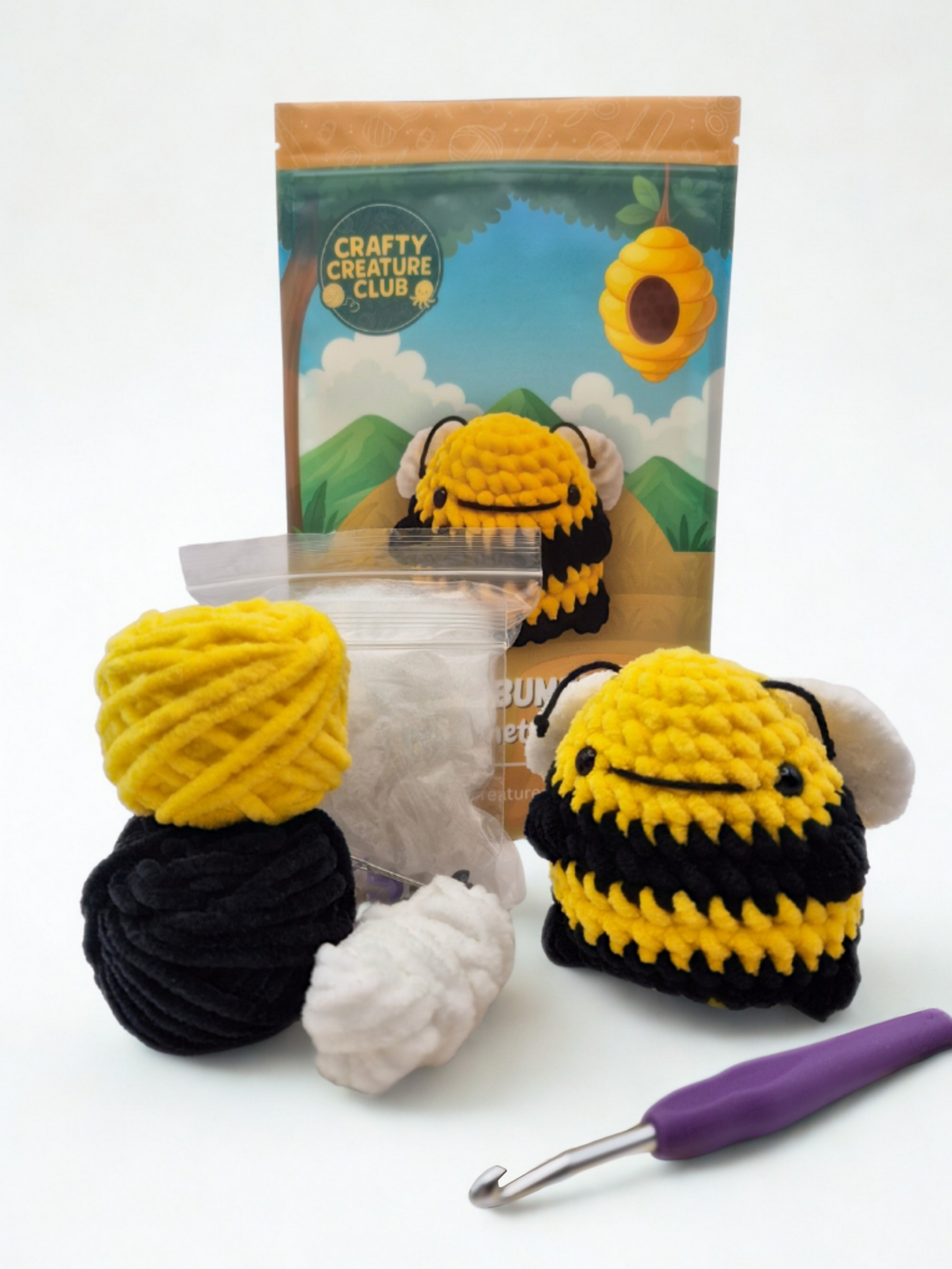Full contents of the Kobe bumblebee crochet kit including plush yarn, hook, stuffing, safety eyes and pattern