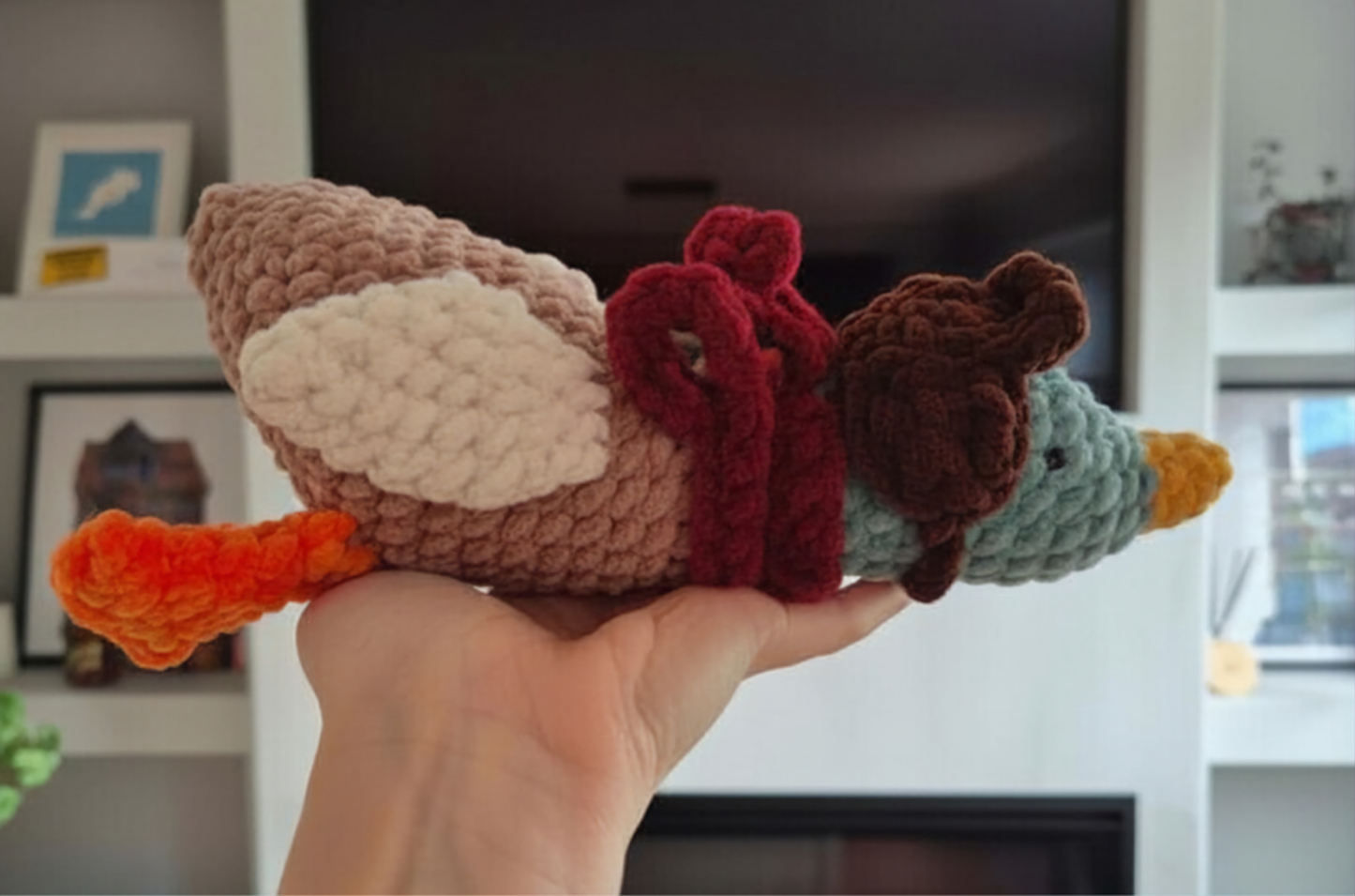 Side view of Reed the mallard duck crochet plush showing the aviator hat, scarf and detailed amigurumi duck design.
