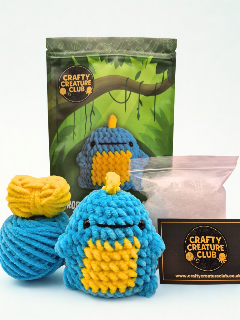 Full contents of the Rory dinosaur crochet kit including plush yarn, pattern, crochet hook, stuffing and safety eyes
